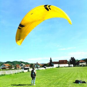Ozone Swift 6 paraglider in vibrant yellow, marine blue, and black colors, designed for expert pilots seeking thrilling adventures