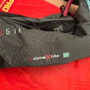 Image of a gently used Gin Genie X-Lite paragliding harness (size M) lying open on the ground, showcasing its sleek design.