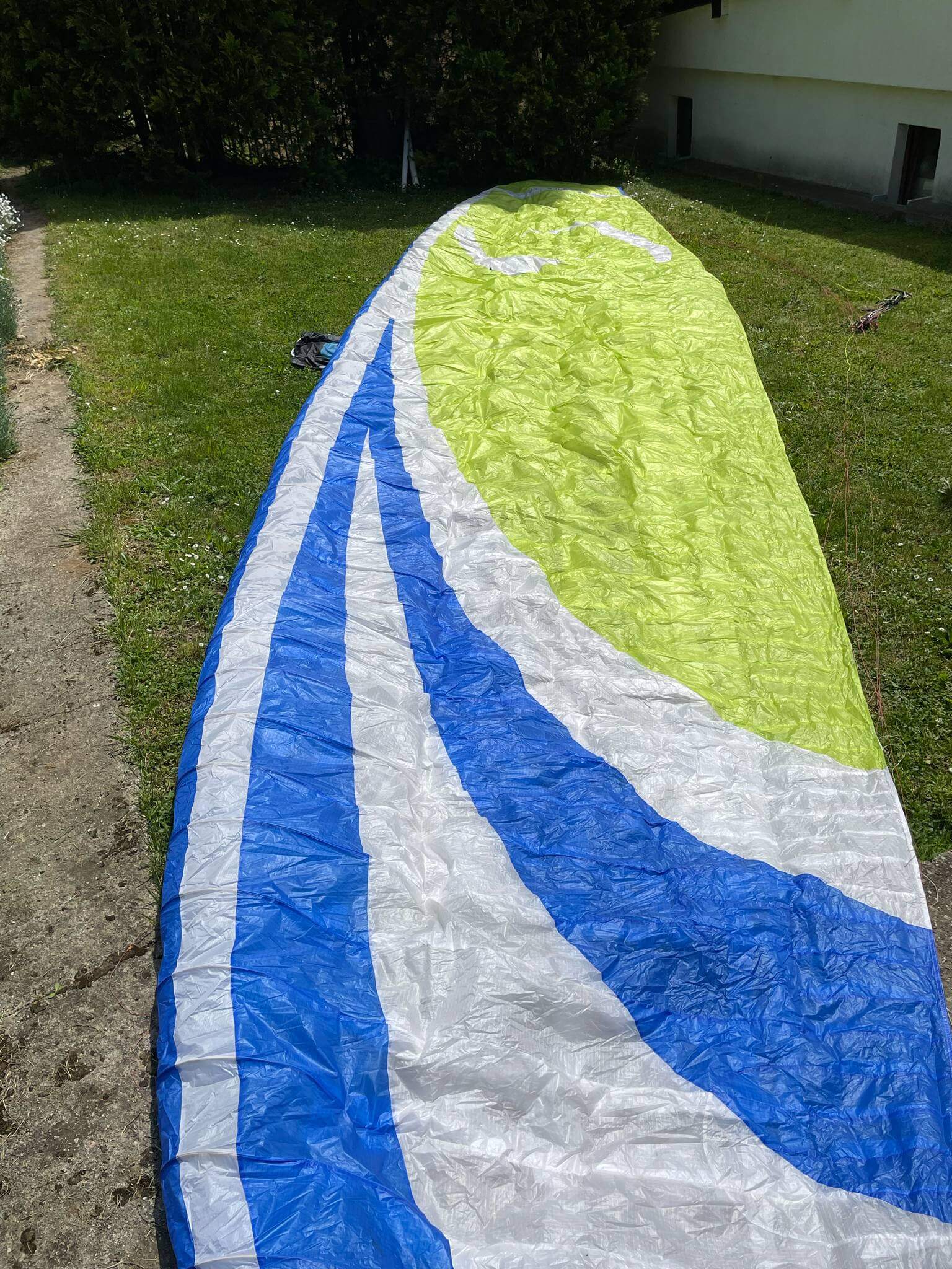 Supair Savage paraglider with Gin Genie X-Lite pod harness laid out, perfect ultralight combo in mint condition, photographed in daylight