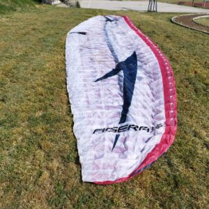 Swing Agera RS paraglider in ML size laid out in grassy field, in excellent condition with one small patch on leading edge.