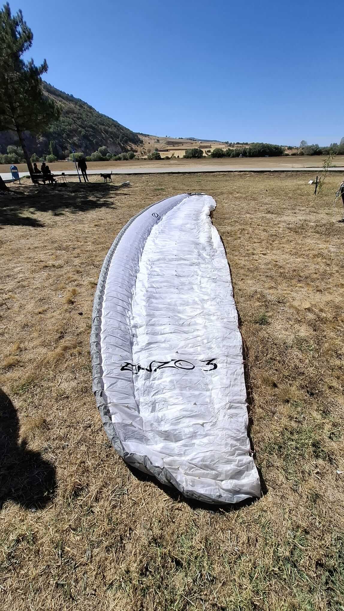Ozone Enzo 3 paraglider in very good condition, ready for competition and long XC flights, photographed during setup on takeoff.