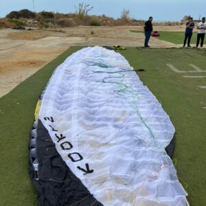 Sky Kooky 2 tandem paraglider in black, white, and yellow colors lying ready for flight — pure acro paraglider for sale, like new condition.